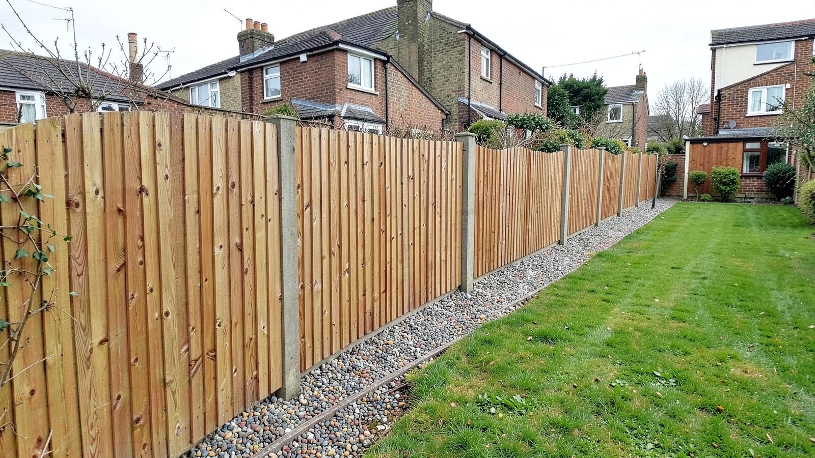 Example of a new closeboard fence with concrete posts and gravel boards along a long suburban rear boundary