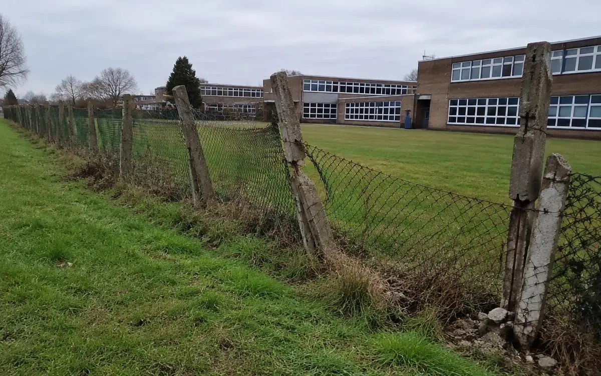 Example before: Old chain-link on failing concrete posts, with gaps along the playing field edge.