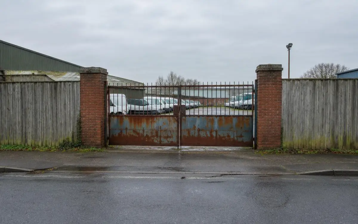 Example before: Weathered timber hoarding and a rusted gate on a street frontage.